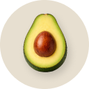 Half-cut avocado on a white plate